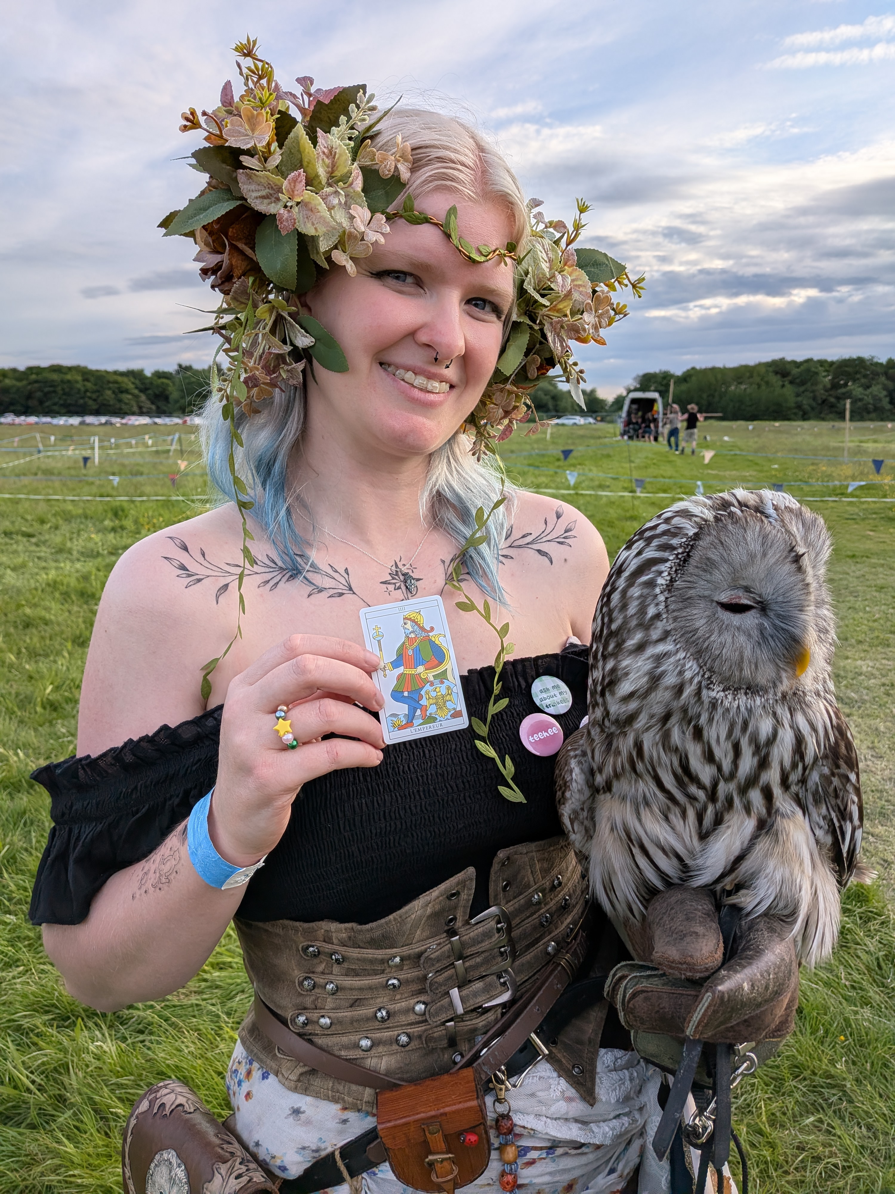 Renaissance festival performer holds and owl in one hand, tarot card in the other
